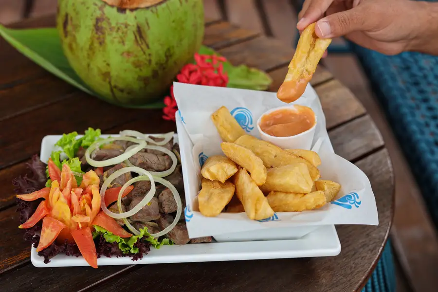 Porção de carne de sol com macaxeira e água de coco