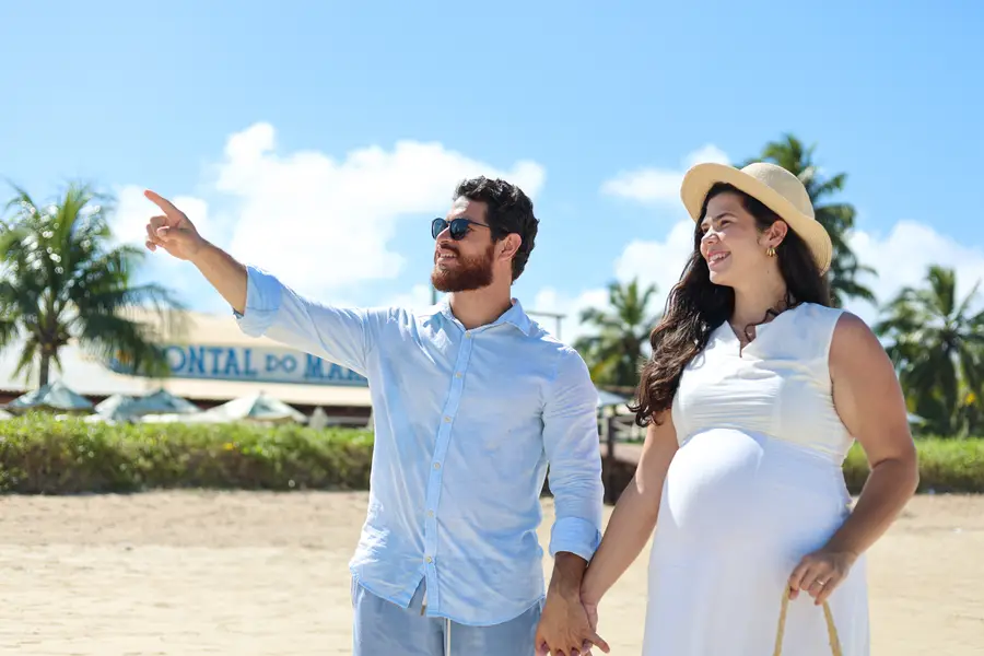 Casal caminhando na praia em frente ao Pontal do Maragogi
